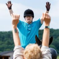 Boy with hands up and coach with hands up demonstrating
