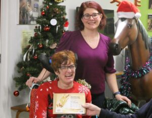 Emma receives her Gold Horse care certificate. She is wearing a Christmas Jumper.